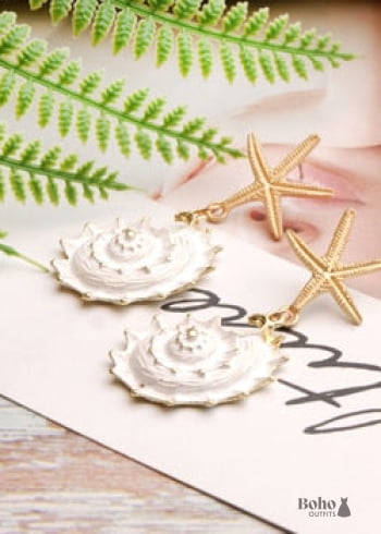 Pendientes bohemios colgantes de concha de estrella de mar y cauri en oro blanco.